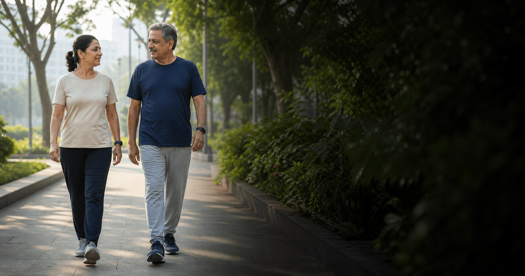 Two middle-aged adults taking a relaxed morning walk on a tree-lined city path